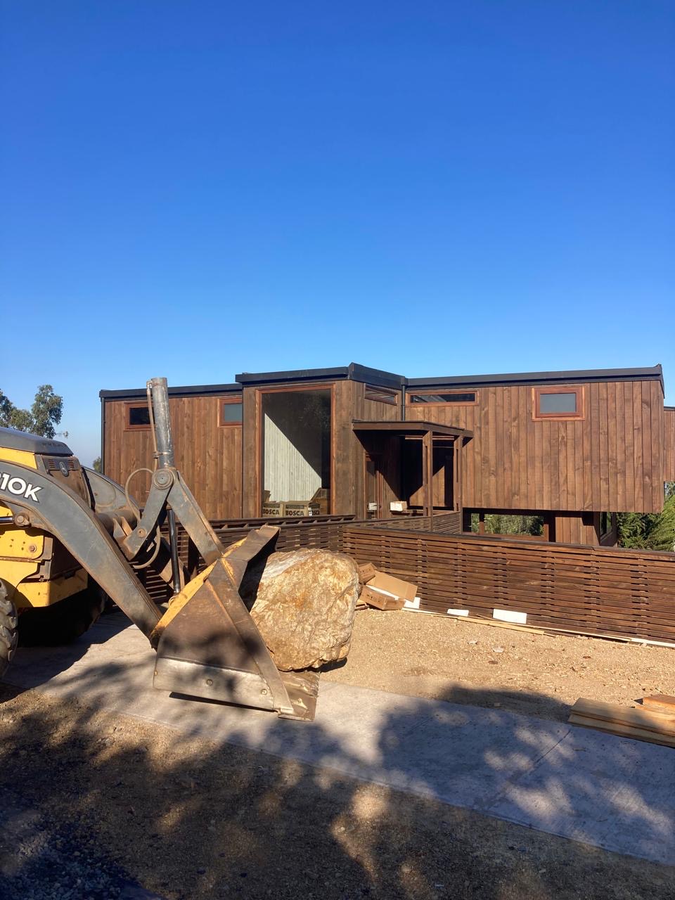 Casa de madera del condominio Remi con las primeras rocas del jardín xerófilo