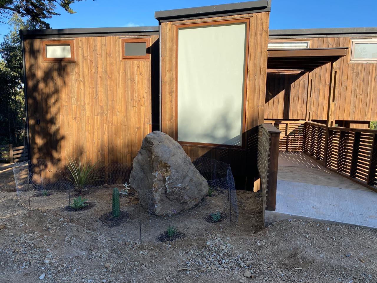 Roca de gran tamaño y suculentas junto a la terraza en Remi